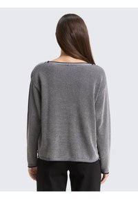 Schwarz-weißer Strickpullover mit strukturierter Musterung, weitem Halsausschnitt und langen Ärmeln, mit lockerem Schnitt und kontrastierendem Besatz.