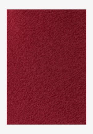 Syvä punainen teksturoitu kangas, jossa on aaltoileva kuvio. Pintaa näyttää pehmeältä ja ylelliseltä, sopii verhoiluun tai koristeelliseen käyttöön.