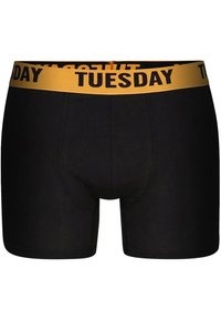 Černé boxerky vyrobené z měkké tkaniny, s elastickým žlutým páskem v pase a nápisem "ÚTERÝ" v tučném černém písmu.