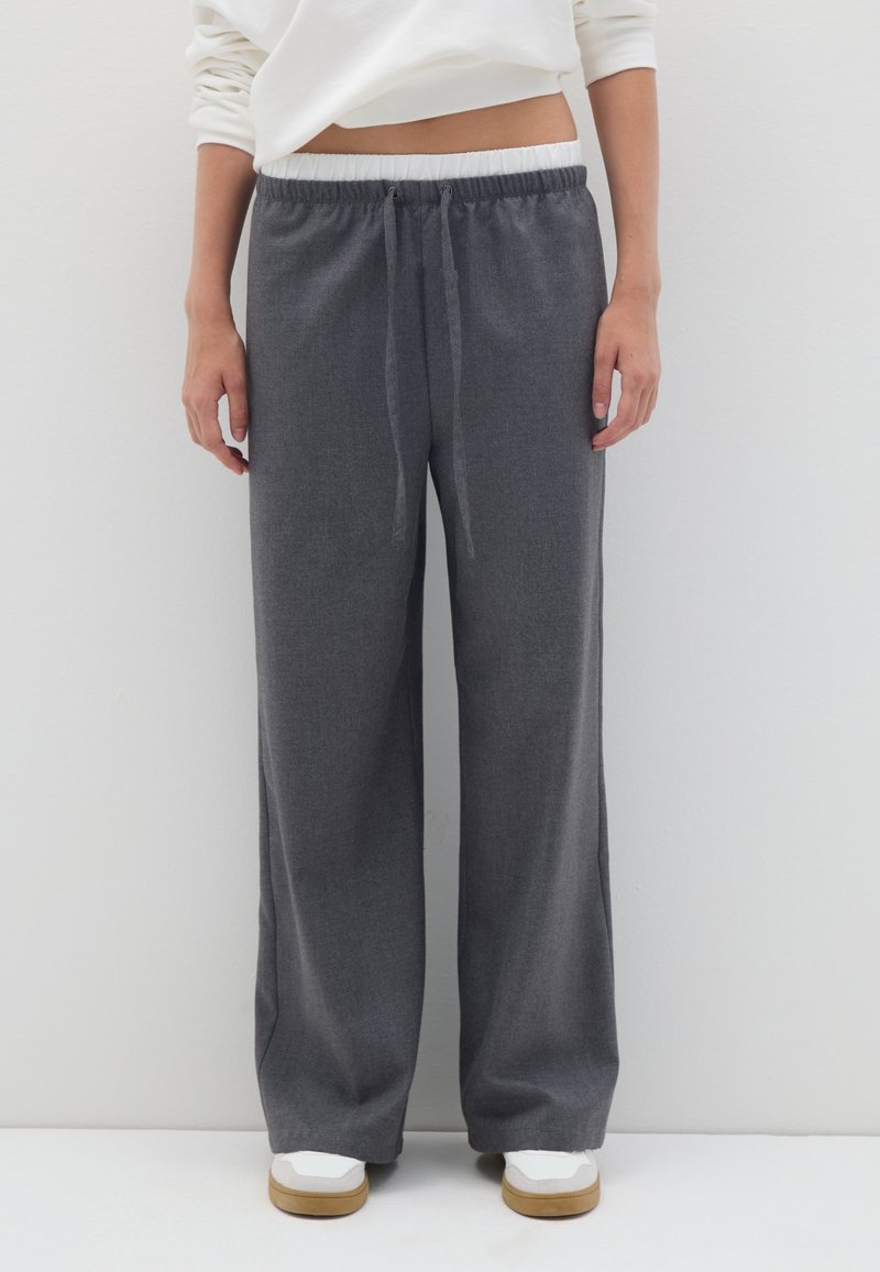 Pantalons gris à jambes larges en matériau doux, dotés d'une taille élastique avec cordon de serrage et d'un motif texturé subtil.