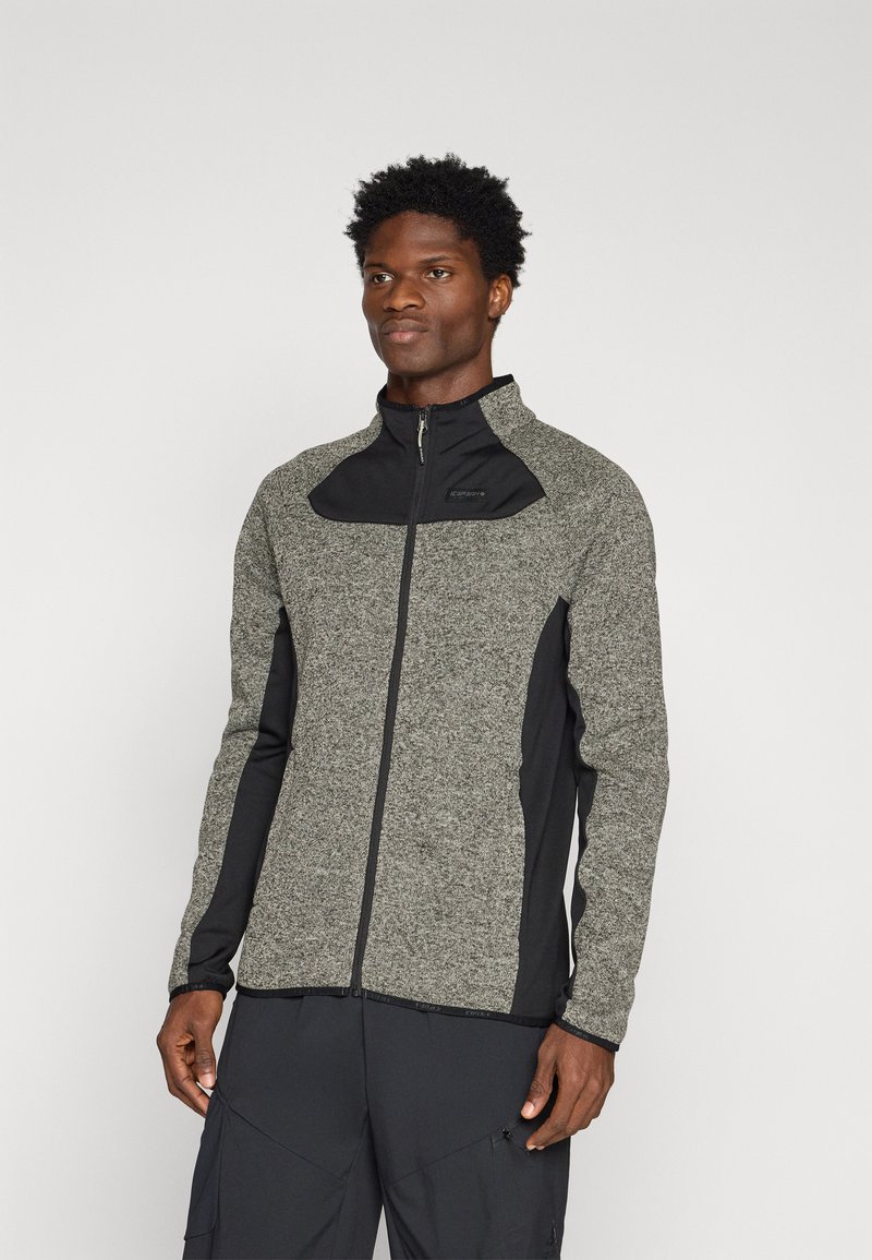 Szara i czarna kurtka zapinana na zamek z teksturowanym wzorem, z wysokim kołnierzem i kontrastowymi panelami, dopasowany krój, wykonana z elastycznego materiału.