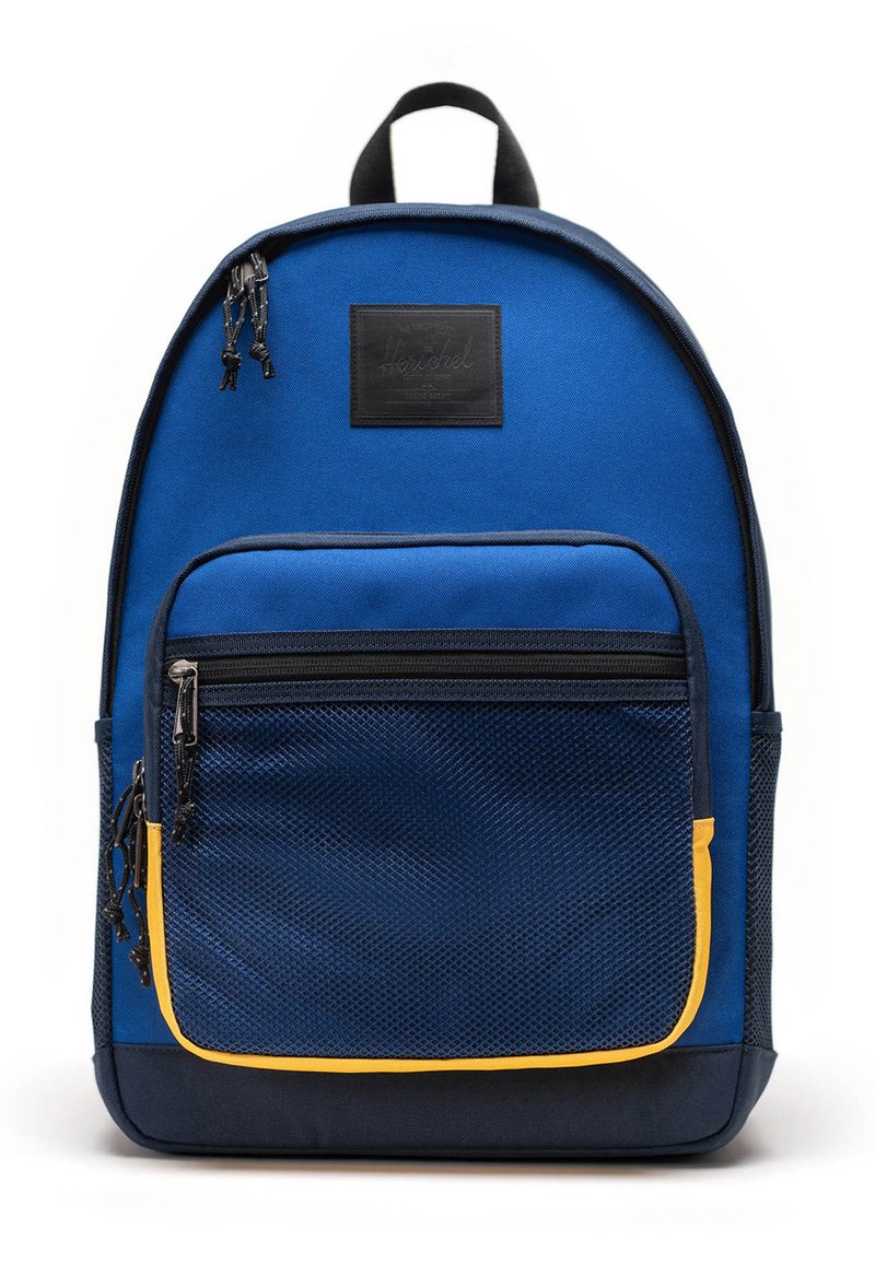 Zaino in tessuto blu con tasca a rete frontale e accenti gialli. Caratterizzato da una maniglia superiore, cerniere e una patch del marchio sul davanti.
