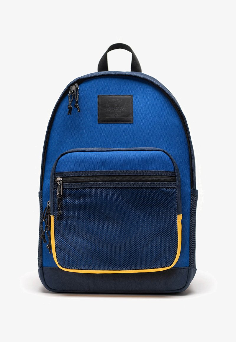 Zaino in tessuto blu con tasca a rete frontale e accenti gialli. Caratterizzato da una maniglia superiore, cerniere e una patch del marchio sul davanti.