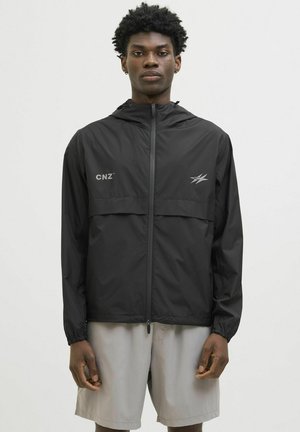 Veste légère noire avec un design à demi-fermeture éclair, dotée d'une poche poitrine et de poignets élastiques. Comprend le logo "CNZ" et des accents réfléchissants.