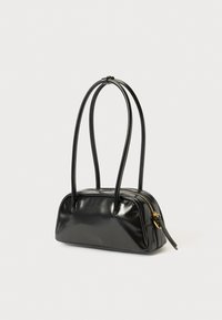 Bolso de cuero negro con una textura lisa y brillante, cierre de cremallera y dos asas largas. Forma redondeada con un diseño minimalista.