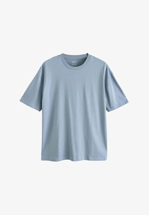 Világoskék, rövid ujjú pamut póló. Kerek nyakkal és laza fazonnal, egyenes aljjal rendelkezik. Minimalista dizájn, minta nélkül.