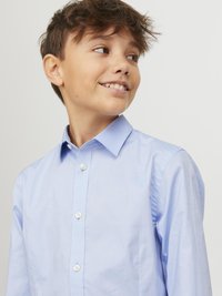 Chemise à manches longues bleu clair, en tissu doux, dotée d'un col classique et de boutons blancs, conçue pour un ajustement décontracté.