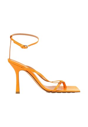 Orange højhælet sandal med tynde stropper, firkantet tå og ankelrem med spænde.