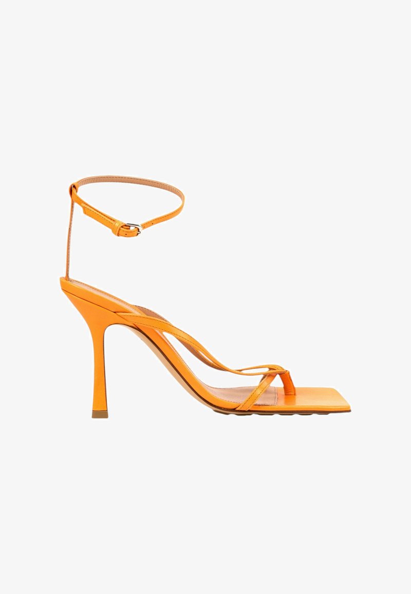 Sandale orange à talon haut avec de fines lanières, un bout carré et une bride à la cheville avec une fermeture à boucle.