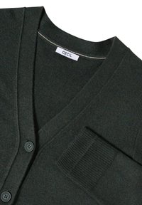 Tmavě zelený kardigan s výstřihem do V, obsahující dvě knoflíkové zapínání, žebrované manžety a kapsu. Vyrobeno z měkké látky s texturovaným povrchem.