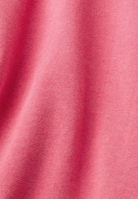 Mjuk rosa tyg med en fin texturerad stickning, som har en slät yta och subtil elasticitet, perfekt för avslappnad klädsel.