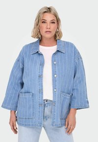 Gaišs zils džinsa jaka ar vertikālām baltām svītrām, pogu aizdare priekšā, plašām piedurknēm un divām priekšējām kabatām. Gluda tekstūra, ikdienišķs dizains.