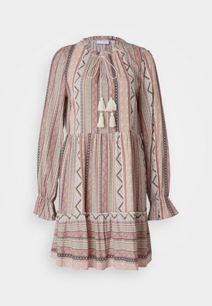 Langermet kjole med snøring i halsen, frynser og et lagdelt skjørt. Stoffet har et rosa og kremfarget geometrisk mønster.
