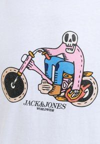 Skeletroosa nahaga mootorrattal, millel on oranžid ja sinised detailid, all valgel taustal kiri "JACK&JONES WORLDWIDE".