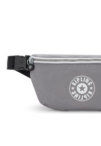 Marsupio in nylon grigio con zip e logo bianchi, caratterizzato da una forma curva, una tracolla nera regolabile e una texture liscia.