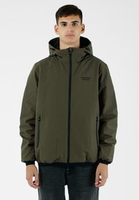 Giacca impermeabile verde oliva con cappuccio, cerniera frontale e due tasche laterali. Presenta dettagli neri e un design a vestibilità ampia.