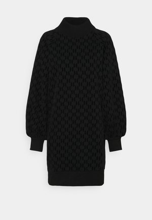 Robe noire en tricot avec un col haut, un motif texturé, des manches ballon et des poignets et un ourlet côtelés.