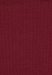 Fast tyg i mörkröd färg med en fin ribbad stickstruktur, som visar subtila vertikala linjer och en mjuk materialyta.