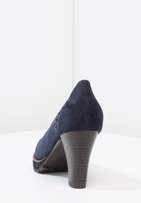 Námořnické semišové vysoké podpatky s zužujícím se designem, obsahující dřevěný podpatek a texturovanou podrážku, s šněrováním na straně.