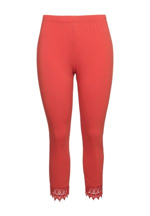 Koralli lyhyet leggingsit pehmeästä materiaalista, joissa on joustava vyötärö ja pitsihelma. Yhteensä sileä rakenne.