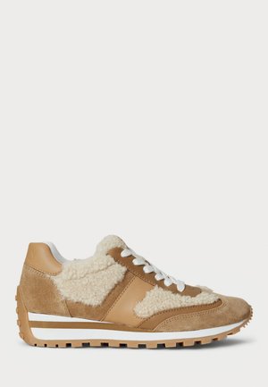 Beżowo-brązowy sneaker z białymi sznurowadłami, panelami z baraniny i zamszu, teksturowaną podeszwą oraz paskowaną środkową podeszwą, pokazany z profilu na białym tle.