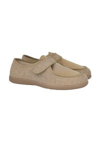 Zapatos de tela beige con una correa de velcro, diseño de punta redondeada y una parte superior de textura suave. Suela de goma para agarre y comodidad en entornos casuales.
