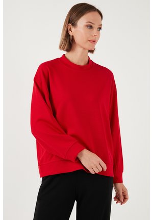 Red sweatshirt with a round neckline, long sleeves, and a relaxed fit. Made from soft material with minimal seams and a smooth texture.
