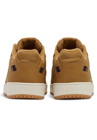 Bruna lädersneakers med mjuk, tanfärgad pälsfoder. Har en vit gummisula och mörkblå detaljer. Rundad form med strukturerade paneler.