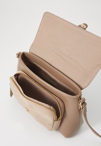 Hnedá crossbody taška vyrobená z hladkých a zamše materiálov, s prednou vreckom na zips, zlatými kovovými doplnkami a priestrannou hlavnou komorou.