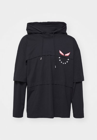 Felpa nera a strati con collo alto, dotata di tasca frontale, grafiche di ali rosse a contrasto e un motivo a stelle sul lato sinistro.