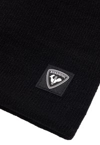 Tessuto a maglia nero con un patch triangolare Rossignol in bianco e nero che presenta il profilo di un gallo.