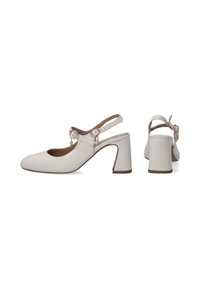 Bílé slingback podpatky s kulatou špičkou, masivním podpatkem a nastavitelným páskem kolem kotníku se zdobnými detaily. Hladká kožená textura.