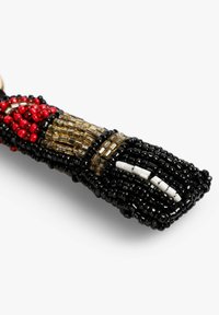 Llavero de cuentas con cuentas de vidrio negras, rojas y doradas. Diseño intrincado con una superficie texturizada y un patrón distintivo.