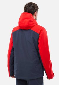 Wasserabweisende Jacke mit rohem Kapuze und Schultern sowie einem marineblauen Körper. Glatte Textur, volle Ärmel und verstellbare Kapuze für einen perfekten Sitz.