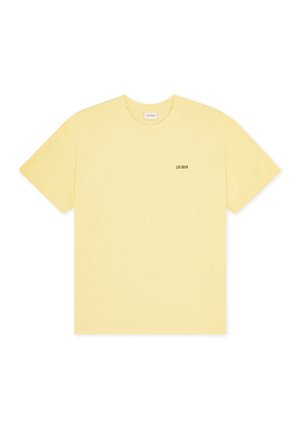 Κίτρινη βαμβακερή μπλούζα με κοντά μανίκια, στρογγυλή λαιμόκοψη και μικρό μαύρο λογότυπο «LES DEUX» τυπωμένο στο αριστερό στήθος.