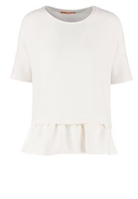 Vit kortärmad topp med ett texturerat övre lager och en volangkant. Enkel rund halsringning och rak skärning.