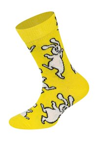 Żółta bawełniana skarpetka z zabawnymi wzorami białych królików, z prążkowanym mankietem i bezszwowym zakończeniem palców. Miękka tekstura i żywy kolor.