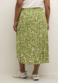 Fustă cu model floral verde, cu un design de frunze albe, fabricată dintr-un material ușor, având un brâu elastic și o formă fluidă.