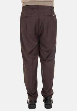 Pantaloni formali marroni con vestibilità su misura, dotati di due tasche posteriori e una texture liscia. Indossati con scarpe nere. Design semplice.