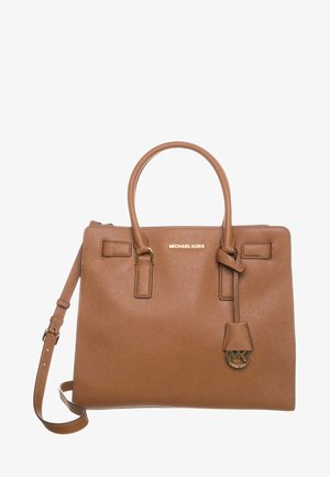 Brązowa skórzana torebka Michael Kors z podwójnymi uchwytami, odpinanym paskiem na ramię oraz złotym zawieszonym logo na jednolitym białym tle.