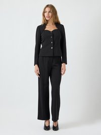 Svart skreddersydd dress med en tilpasset blazer med krage, store knapper og vide bukser. Glatt stoff med en elegant finish.