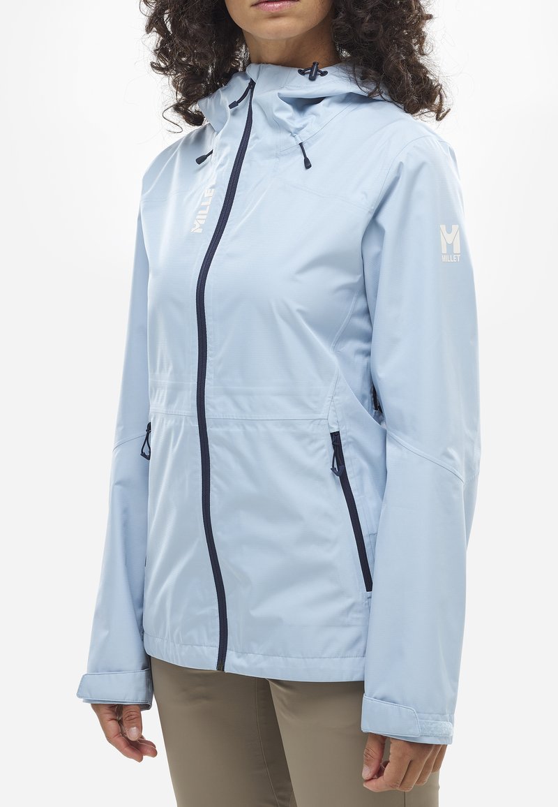 Helle blaue wasserdichte Jacke mit einem Reißverschluss vorne, verstellbare Kapuze, zwei Seitentaschen und Markenlogo auf der linken Schulter. Glatte Textur.