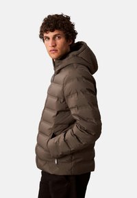 Chaqueta acolchada con capucha en verde oliva oscuro, que cuenta con cierre de cremallera y bolsillos laterales, con una textura suave y duradera y un diseño acolchado.