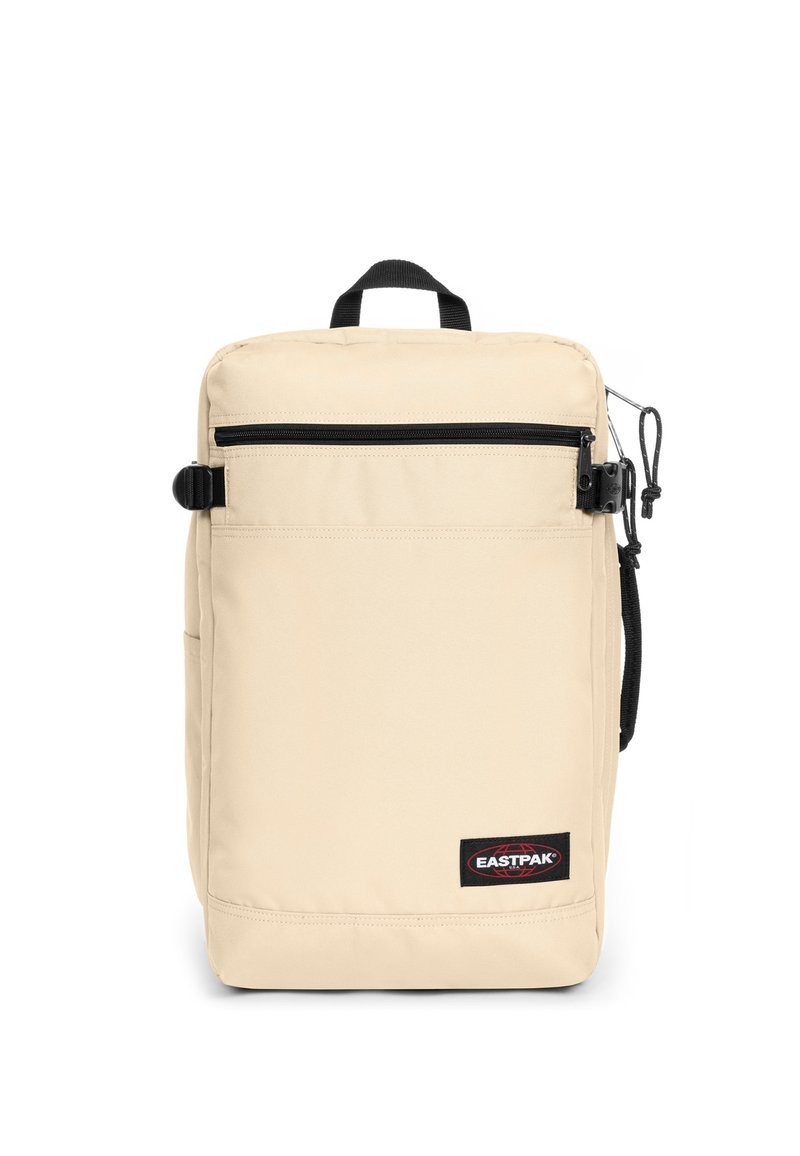 Mochila Eastpak beige con forma rectangular, cremallera negra, bolsillo delantero y tejido texturizado. Cuenta con un asa superior y un lazo lateral.