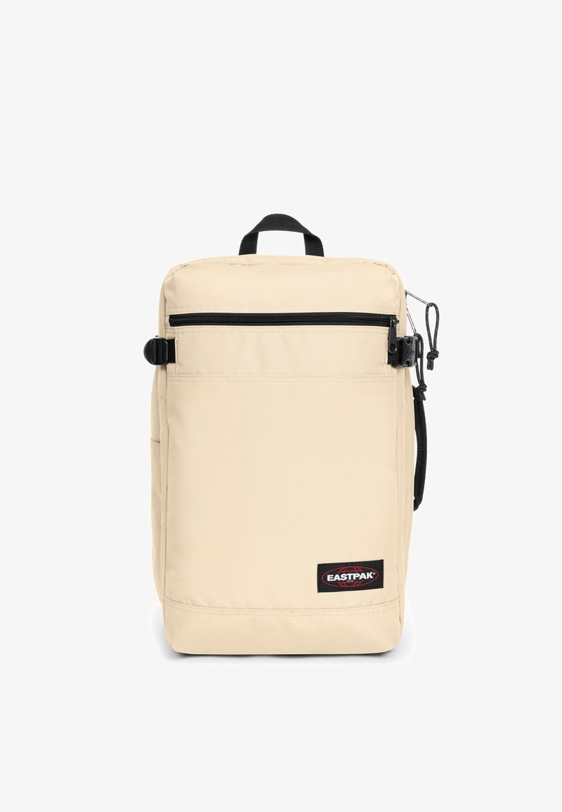 Mochila Eastpak beige con forma rectangular, cremallera negra, bolsillo delantero y tejido texturizado. Cuenta con un asa superior y un lazo lateral.