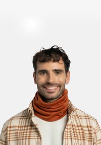 Orange tubular scarf made of textured fabric, worn around the neck. Model wears a plaid shirt with light colors. Simple logo visible on the scarf.
