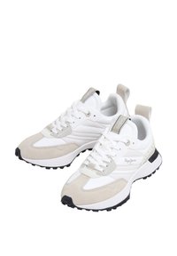 Baltas un bēšas sporta čības ar zamšāda un tīkliņa tekstūrām, melnu gumijas zolīti un mežģīņu aizdari. Papildinātas ar zīmola etiķeti uz papēža.