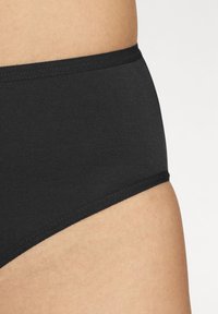 Schwarze Hipster-Unterwäsche aus glattem Stoff mit einem weichen Bund. Verfügt über ein schlichtes Design ohne zusätzliche Muster oder Akzente.