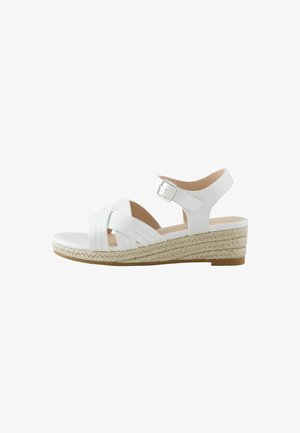 Hvide espadrillesandaler med kilehæl, der har en flettet jutesål og krydsede stropper over tæerne samt en justerbar ankelrem med spænde.