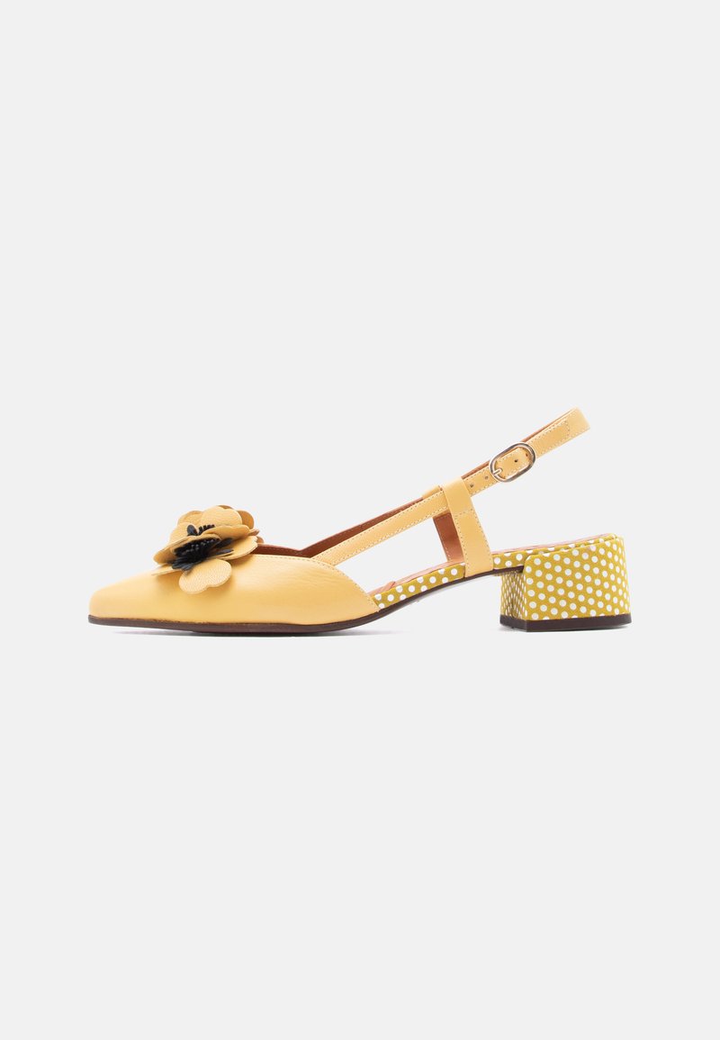 Chaussures slingback en cuir jaune avec un accent floral, un talon carré à motifs à pois et une bride de cheville réglable.